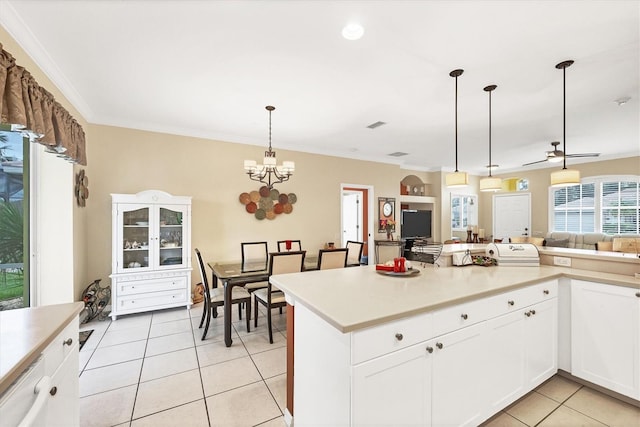 kitchen with ceiling fan with notable chandelier, crown molding, light tile patterned floors, decorative light fixtures, and white cabinetry