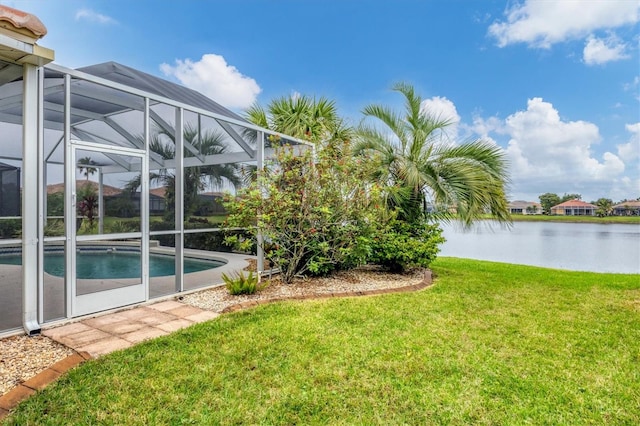 view of yard featuring glass enclosure and a water view