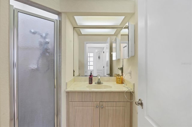 bathroom with vanity and a shower with door