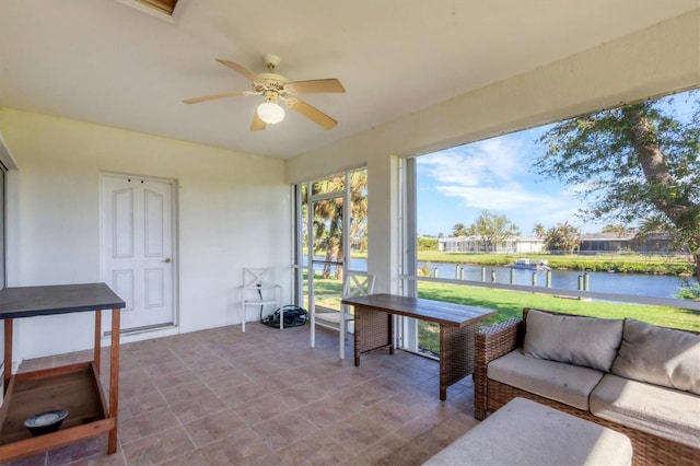 sunroom with a water view and ceiling fan