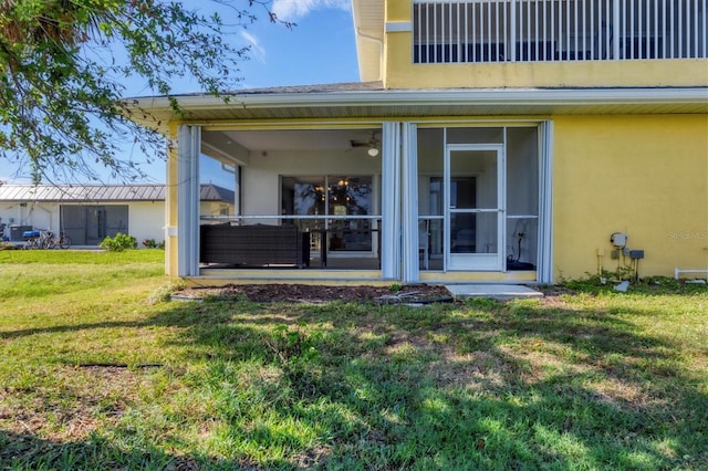 rear view of house featuring a sunroom and a yard