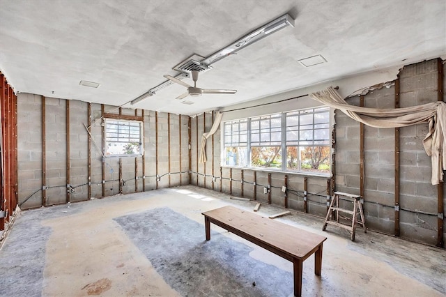 misc room featuring ceiling fan and concrete flooring