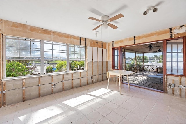 unfurnished sunroom with ceiling fan