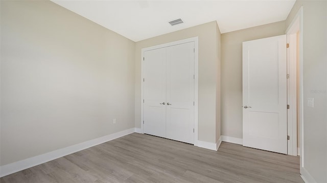 unfurnished bedroom featuring a closet and light hardwood / wood-style floors