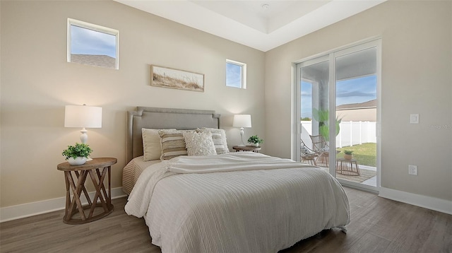 bedroom featuring dark hardwood / wood-style flooring, access to outside, and multiple windows