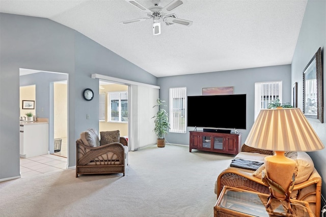 living room with a textured ceiling, ceiling fan, light carpet, and vaulted ceiling