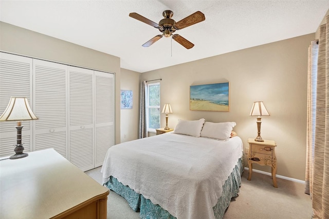 bedroom featuring ceiling fan, light colored carpet, and a closet