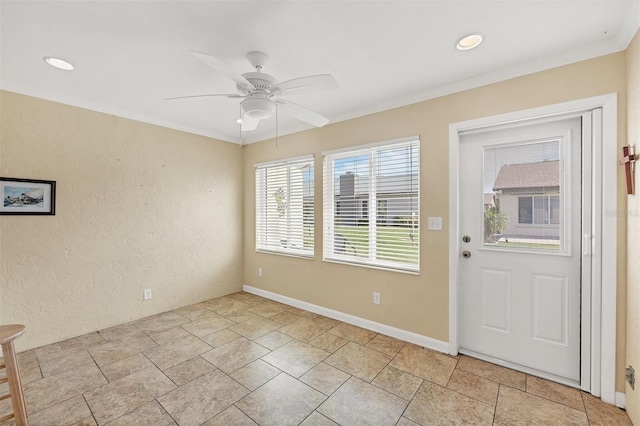 foyer with ceiling fan and crown molding