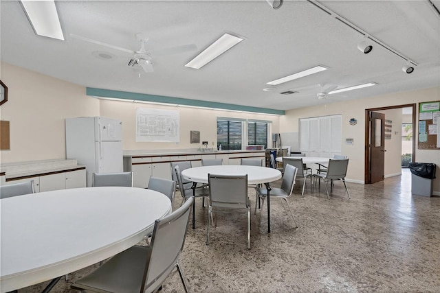 dining area with ceiling fan and a textured ceiling