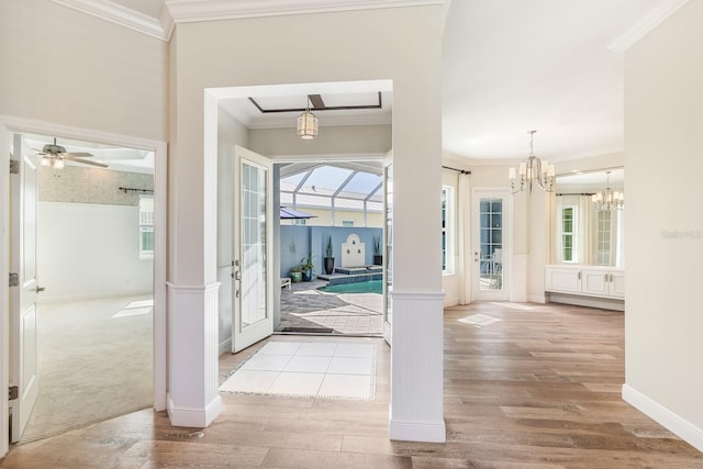 entrance foyer featuring a sunroom, baseboards, crown molding, and wood finished floors