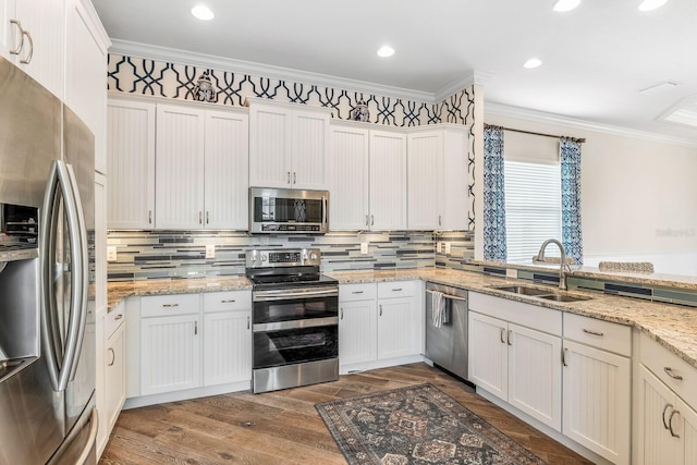 kitchen with dark wood-style flooring, a sink, appliances with stainless steel finishes, tasteful backsplash, and crown molding