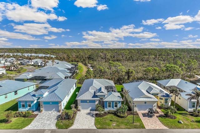 drone / aerial view featuring a wooded view and a residential view