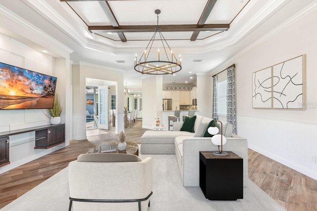 living room with a chandelier, beamed ceiling, wainscoting, and light wood-style floors