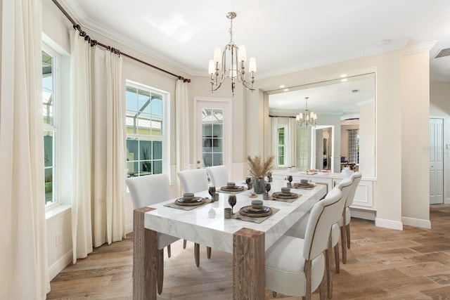 dining area with light wood-style floors, visible vents, ornamental molding, and a notable chandelier