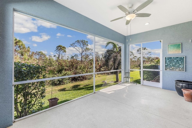 unfurnished sunroom featuring a ceiling fan