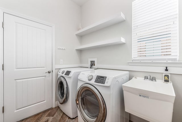 laundry area featuring dark wood-style floors, laundry area, a sink, and washer and dryer