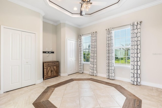 tiled foyer featuring baseboards, ceiling fan, a tray ceiling, crown molding, and recessed lighting