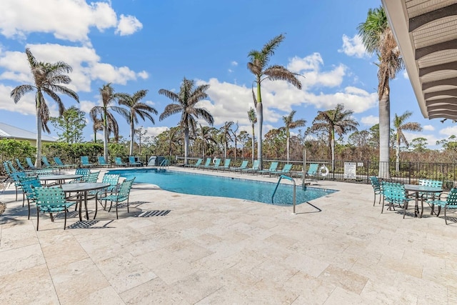 pool with a patio area and fence