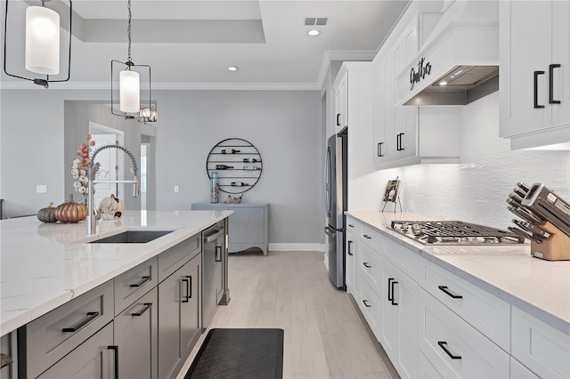 kitchen featuring white cabinetry, sink, stainless steel appliances, and light stone counters