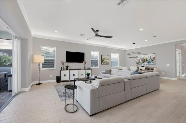 living room featuring ceiling fan, ornamental molding, and light hardwood / wood-style flooring