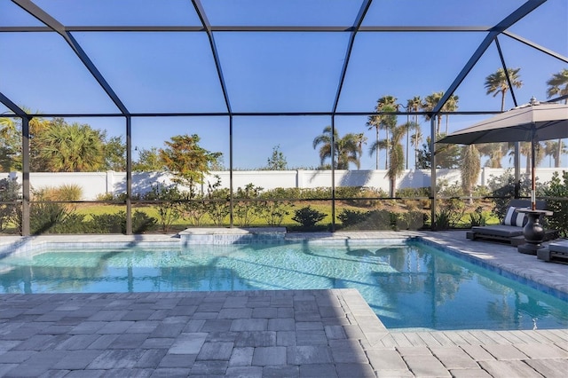 view of swimming pool with glass enclosure and a patio area