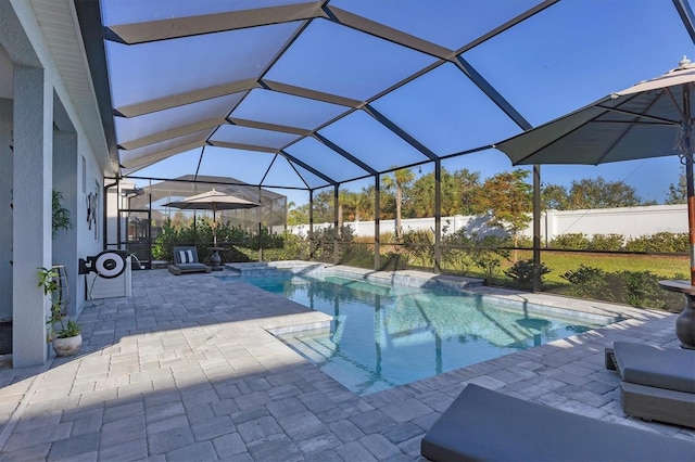 view of pool with glass enclosure and a patio area