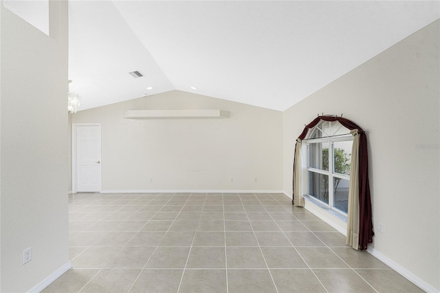 tiled empty room featuring vaulted ceiling