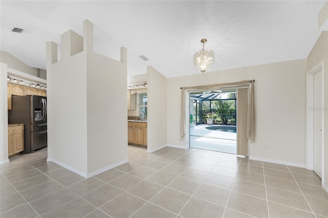 entryway featuring sink, a notable chandelier, lofted ceiling, and light tile patterned flooring