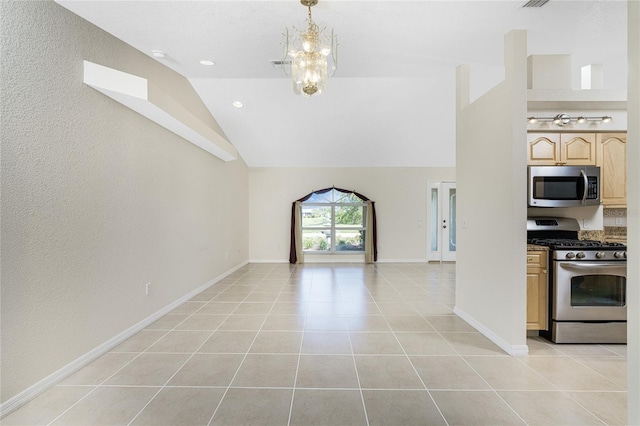 kitchen featuring light tile patterned flooring, stainless steel appliances, lofted ceiling, and a notable chandelier