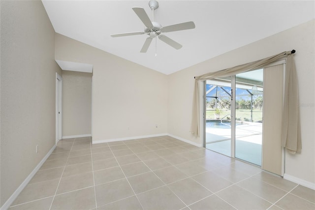 spare room featuring light tile patterned floors, vaulted ceiling, and ceiling fan