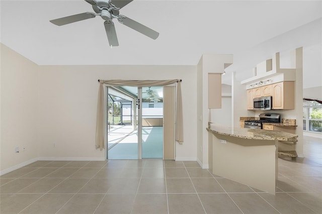 kitchen with light stone counters, light tile patterned flooring, a kitchen bar, kitchen peninsula, and stainless steel appliances