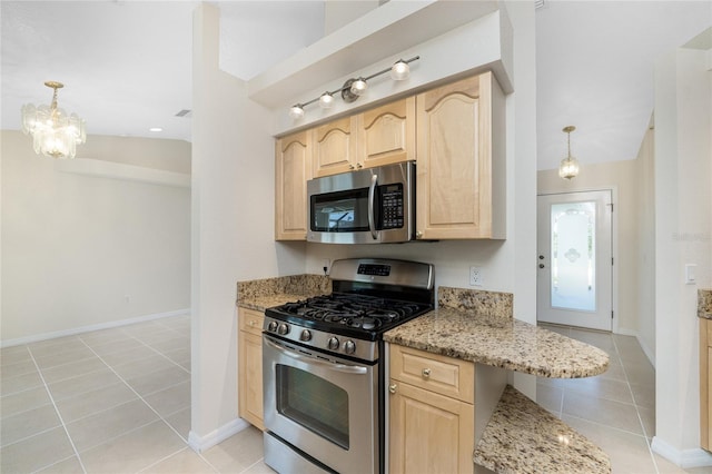 kitchen with light brown cabinets, light tile patterned flooring, pendant lighting, and appliances with stainless steel finishes