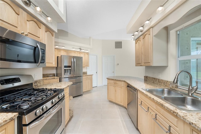 kitchen featuring sink, light stone countertops, light brown cabinetry, light tile patterned flooring, and stainless steel appliances