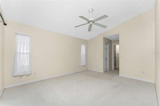 carpeted empty room with vaulted ceiling and ceiling fan