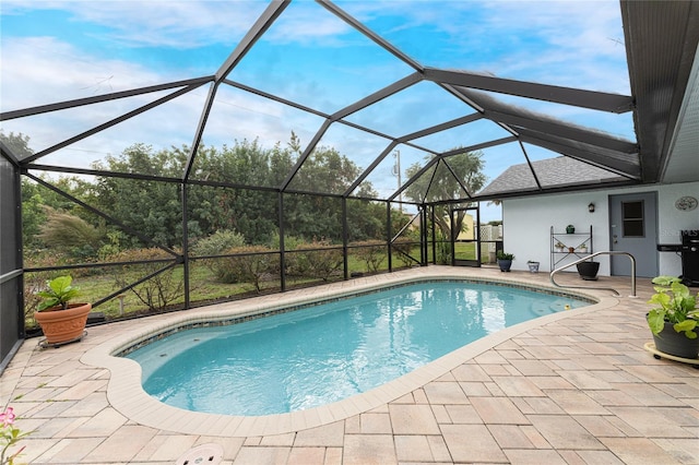 view of swimming pool with a patio area and glass enclosure