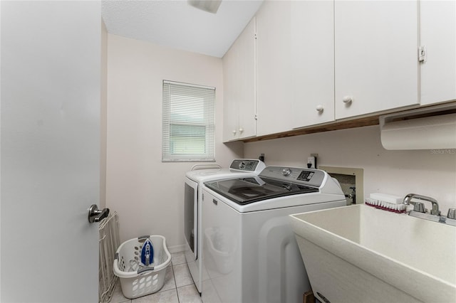 laundry area with cabinets, light tile patterned floors, sink, and washing machine and dryer