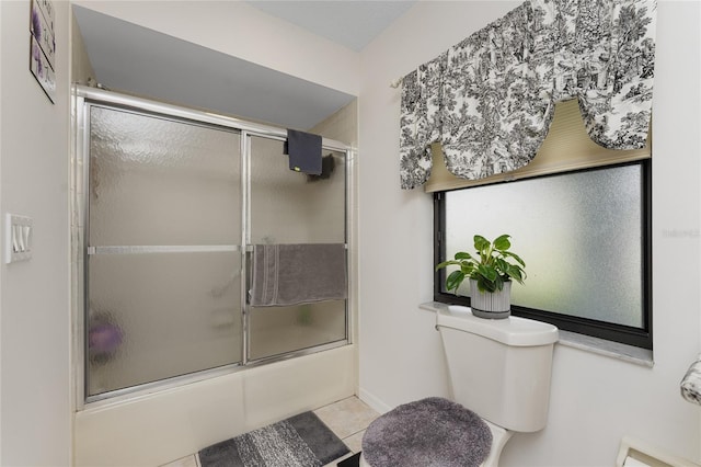 bathroom featuring tile patterned floors, toilet, and combined bath / shower with glass door