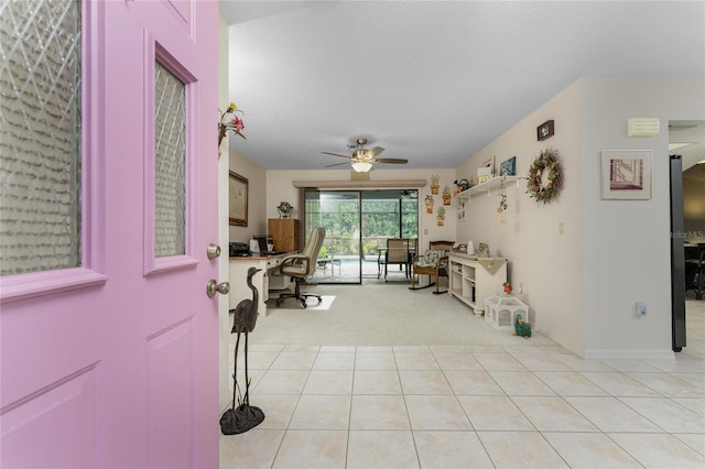 tiled entrance foyer with ceiling fan and a textured ceiling