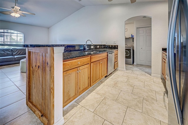 kitchen featuring sink, washer / clothes dryer, lofted ceiling, light tile patterned flooring, and appliances with stainless steel finishes