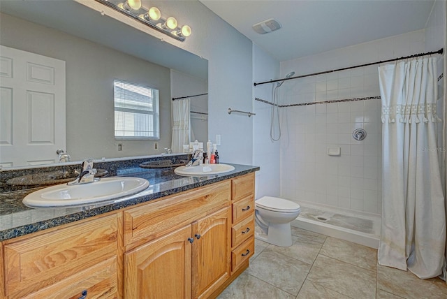 bathroom with tile patterned floors, a shower with curtain, vanity, and toilet