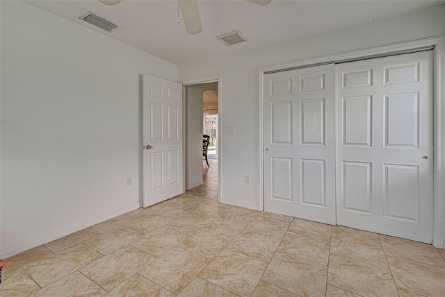 unfurnished bedroom featuring ceiling fan and a closet