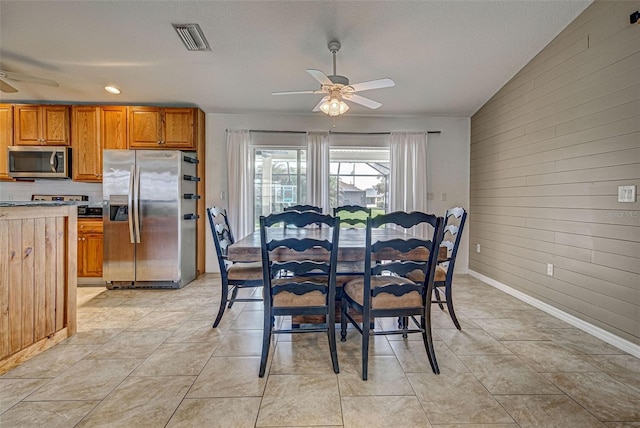 dining room featuring ceiling fan, lofted ceiling, and light tile patterned floors