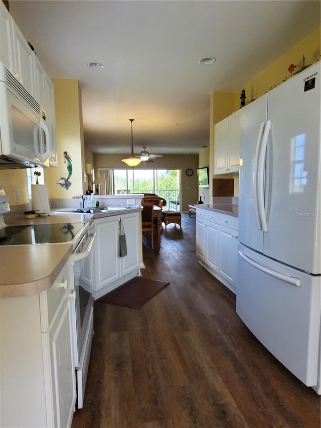 kitchen featuring white cabinets, decorative light fixtures, and white appliances