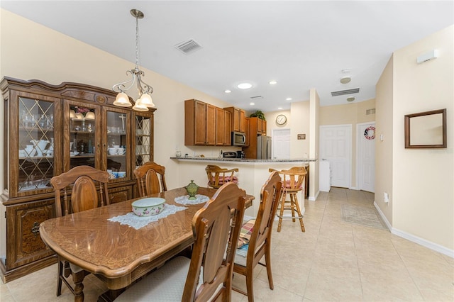 tiled dining room featuring a chandelier