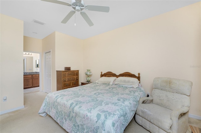 carpeted bedroom with ceiling fan, a closet, and ensuite bath