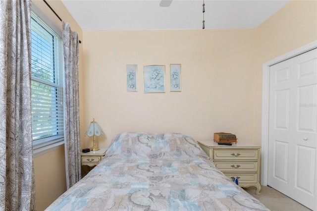 carpeted bedroom featuring ceiling fan and a closet