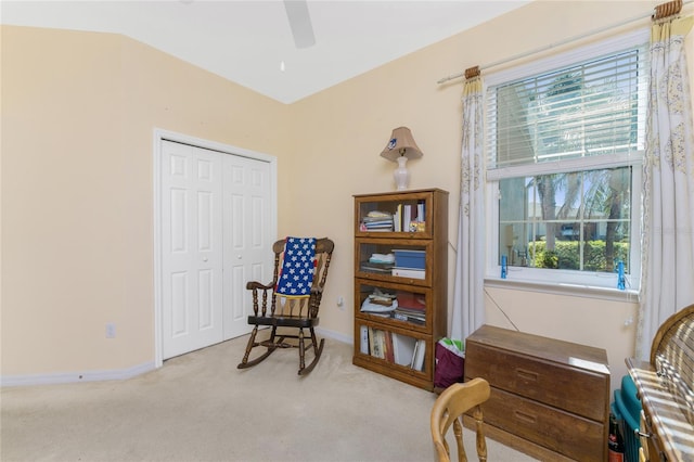 sitting room with ceiling fan, light colored carpet, and vaulted ceiling