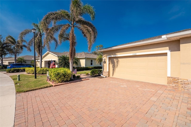 ranch-style home with a garage and a front lawn