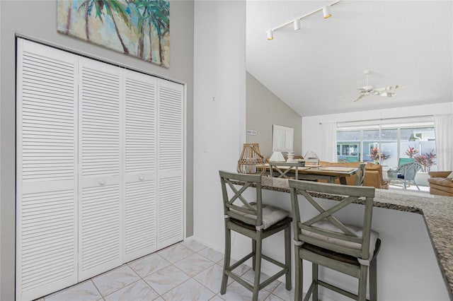 tiled dining area featuring vaulted ceiling and ceiling fan