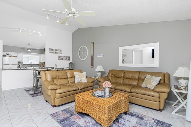 living room with ceiling fan, lofted ceiling, and a textured ceiling